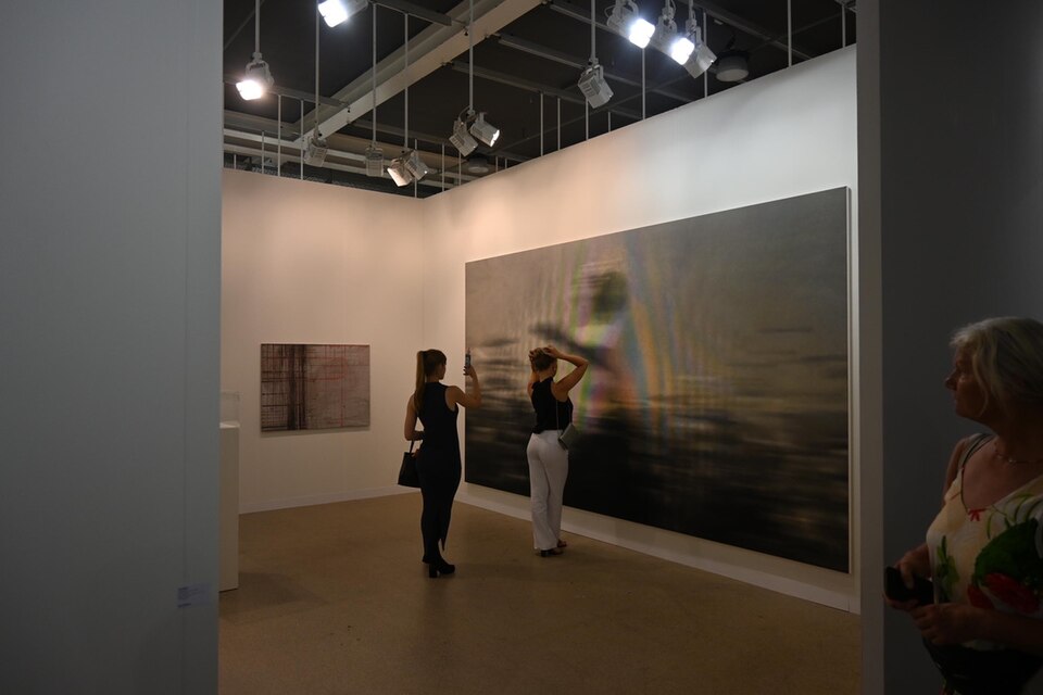 Visitors walking among gallery stands at Art Basel in Basel, Switzerland.
